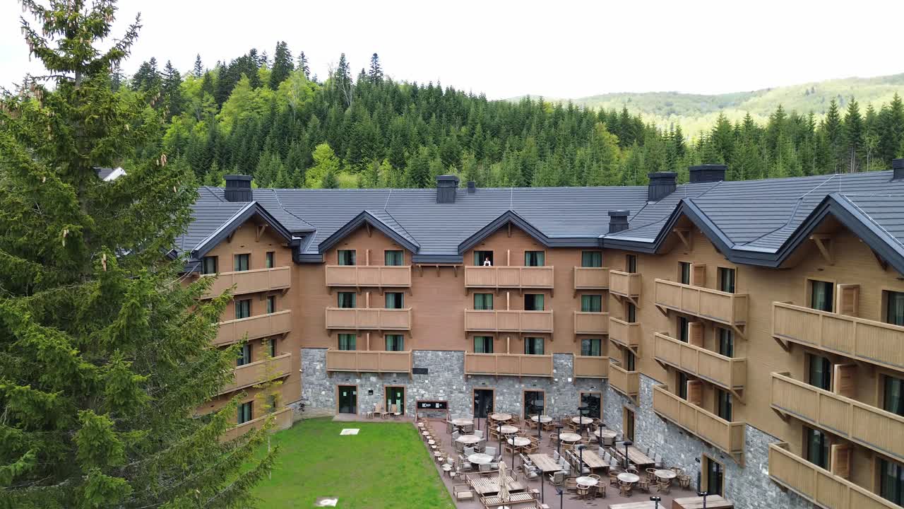 Luxury ski resort and mountain retreat in Kolasin valley surrounded by lush pine forest in summer near Biogradska Gora National Park, Swissotel resort, Revealing drone shot