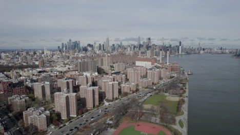 Vista-Aérea-De-Bloques-Residenciales-De-Brooklyn-Al-Lado-De-FDR-Drive-Y-East-River-Con-El-Centro-De-La-Ciudad-Al-Fondo