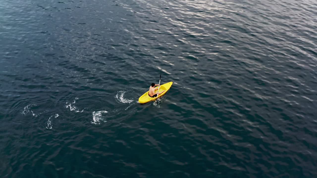 hombre en canoa amarilla remando en el mar azul en verano en filipinas