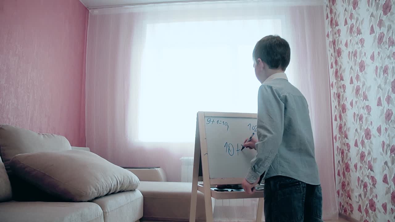 Schoolboy wrote numbers on easel