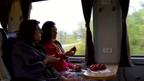 women on the train eating malayan apples