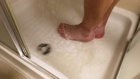 person washing feet in a shower