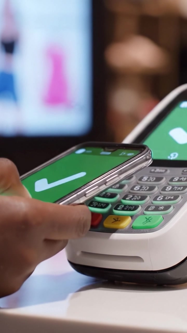 Payment Terminal Displaying Transaction Confirmation with Colorful Buttons in a Retail Environment Featuring Digital Media in Background