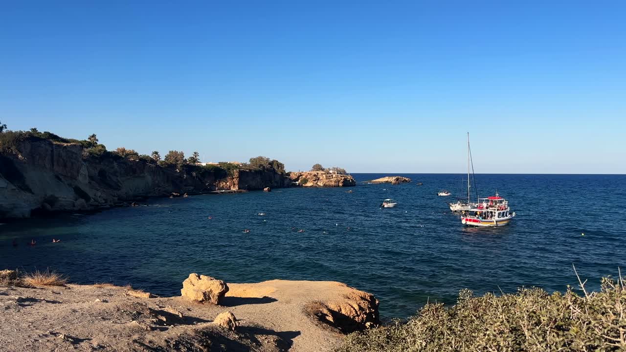 tourist boat anchored in a scenic bay for swimming near rocky cliffs on Crete Island, Greece