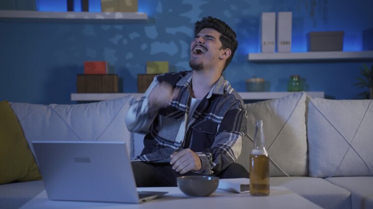 Happy and cheerful young man drinking alcohol.