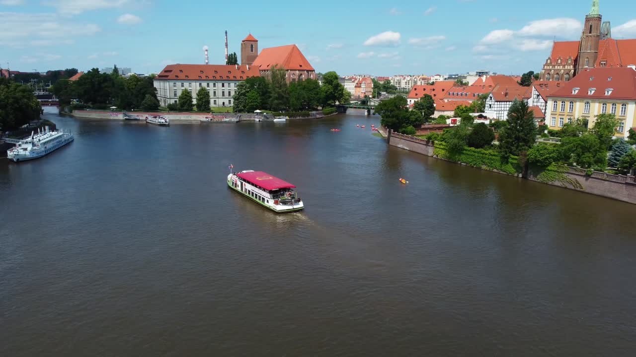 Boat and paddle boarders on River Ora in summer sun, by Cathedral Island - Wroclaw, Poland