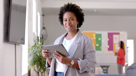 Happy-african-american-casual-businesswoman-using-tablet-in-office,-slow-motion