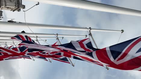 many union jack flags waving in the wind