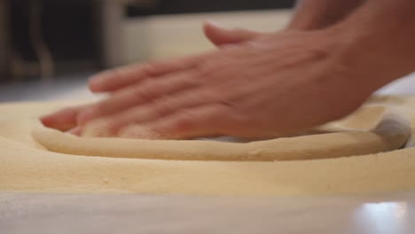 preparing pizza dough on table