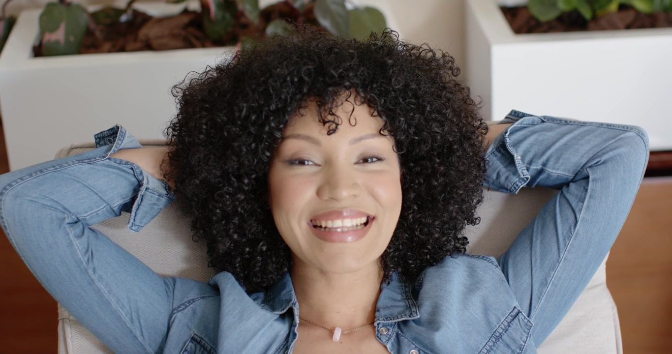 La telecamera si allontana rivelando una donna afroamericana sdraiata tra fioriere, che apre gli occhi