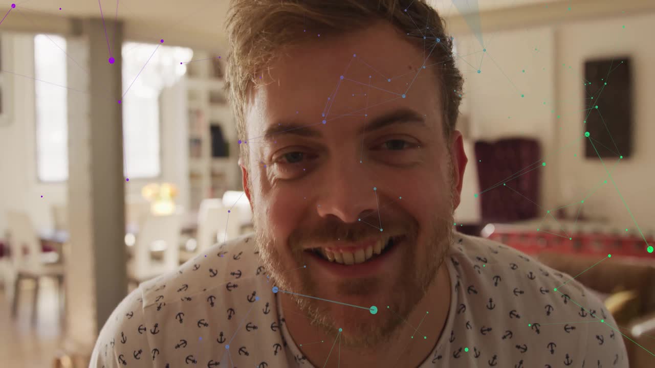 Male facing camera shifting from calm look to smile as emerging technology network overlay evolving