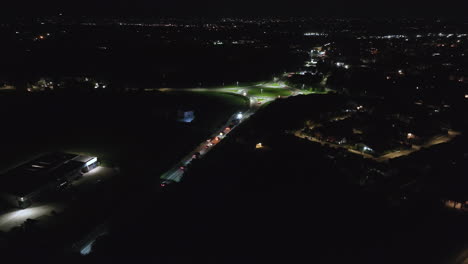 aerial night shot of exceptional convoy approaching a roundabout. drone tracking shot.