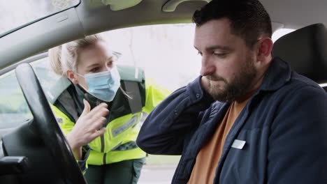 Sanitäterin-Hilft-Einem-Männlichen-Fahrer-Mit-Einer-Schleudertrauma-Nackenverletzung,-Die-In-Einen-Verkehrsunfall-Verwickelt-Ist