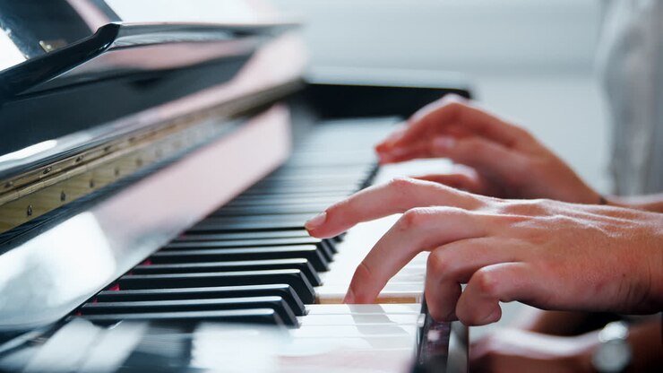 Oppilaan lähikuva opettajan soittaessa pianoa musiikkitunnilla