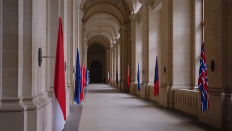 grand hallway adorned with international flags in a historic building