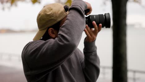 male photographer shooting photos with a professional dslr camera and lens