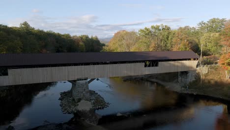 old-fashioned covered bridge for traveling in new england forest landscape - aerial establishing drone view