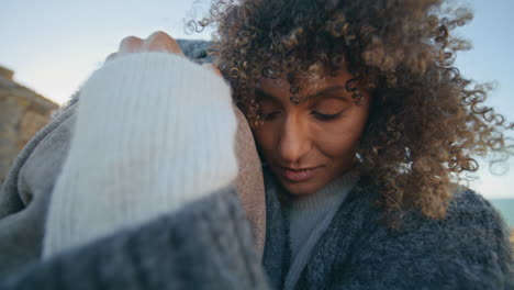 curly girl bonding boyfriend at evening ocean coast closeup. lovers cuddling
