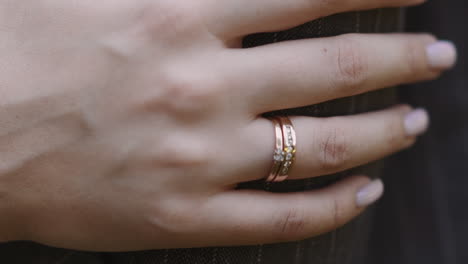 lady with gold wedding ring on finger strokes arm of husband