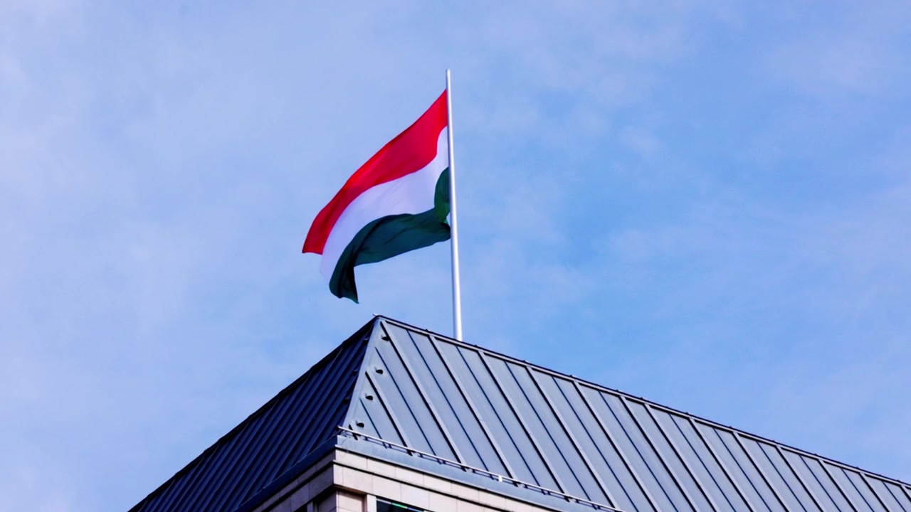 Enorme bandiera italiana che sventola al vento sull'edificio dell'ambasciata a Berlino.