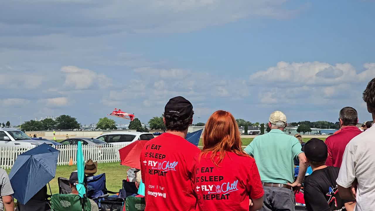 Airshow: Crowd Watching Red Airplane Stunt Performance