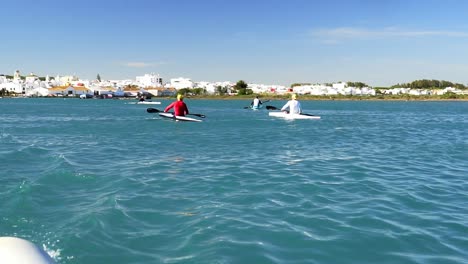 Dolly-out-revealing-several-people-kayaking-on-the-sunny-Spanish-coast