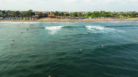 many people surfing in canggu beach in dalung, bali aerial shot