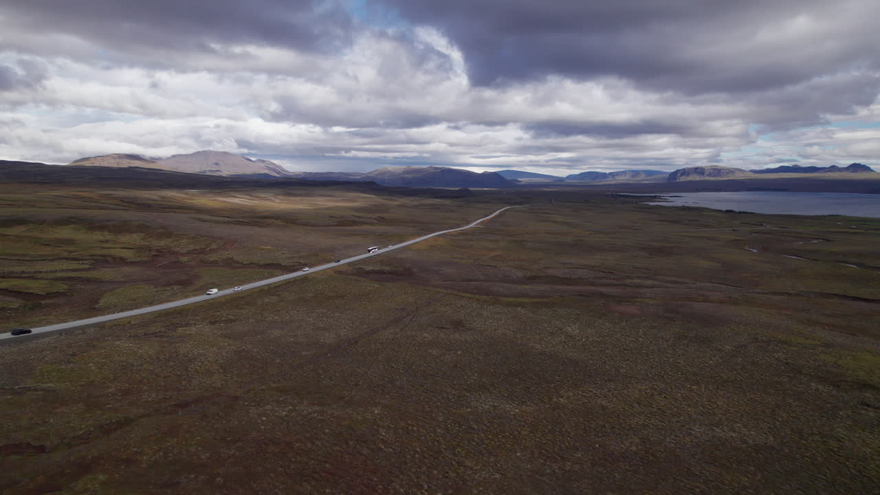 Cars driving to and from Thingvellir National Park on a desolate highway in Iceland, aerial view