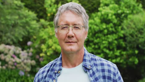 animation of caucasian senior man smiling at camera in garden