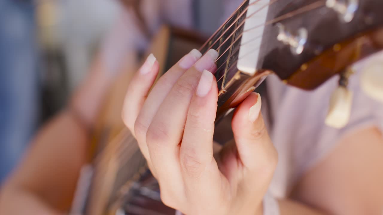 Close-up sequence opening, woman playing acoustic guitar, practicing chords, picking, watch showing
