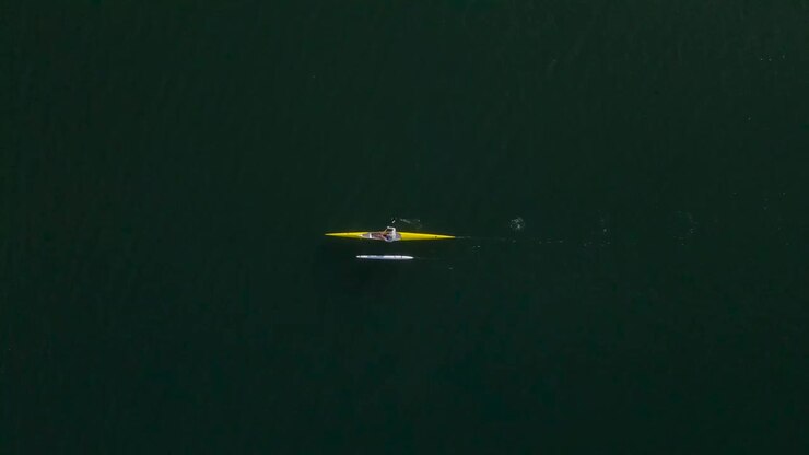 Birdseye view of solo outrigger canoe paddler in open ocean water