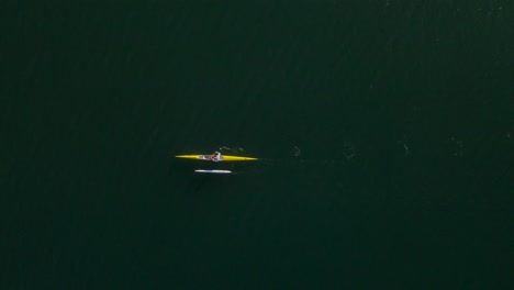 Birdseye-view-of-solo-outrigger-canoe-paddler-in-open-ocean-water