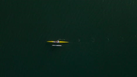 birdseye view of solo outrigger canoe paddler in open ocean water