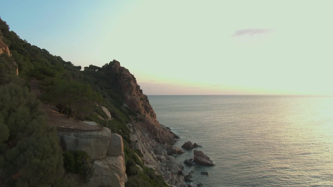 Drone lentää lähellä kallioista muodostelmaa Sardinian itärannikolla auringonlaskun aikaan