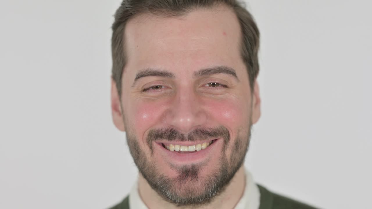 cerca de la cara del hombre sonriendo a la cámara, pantalla blanca