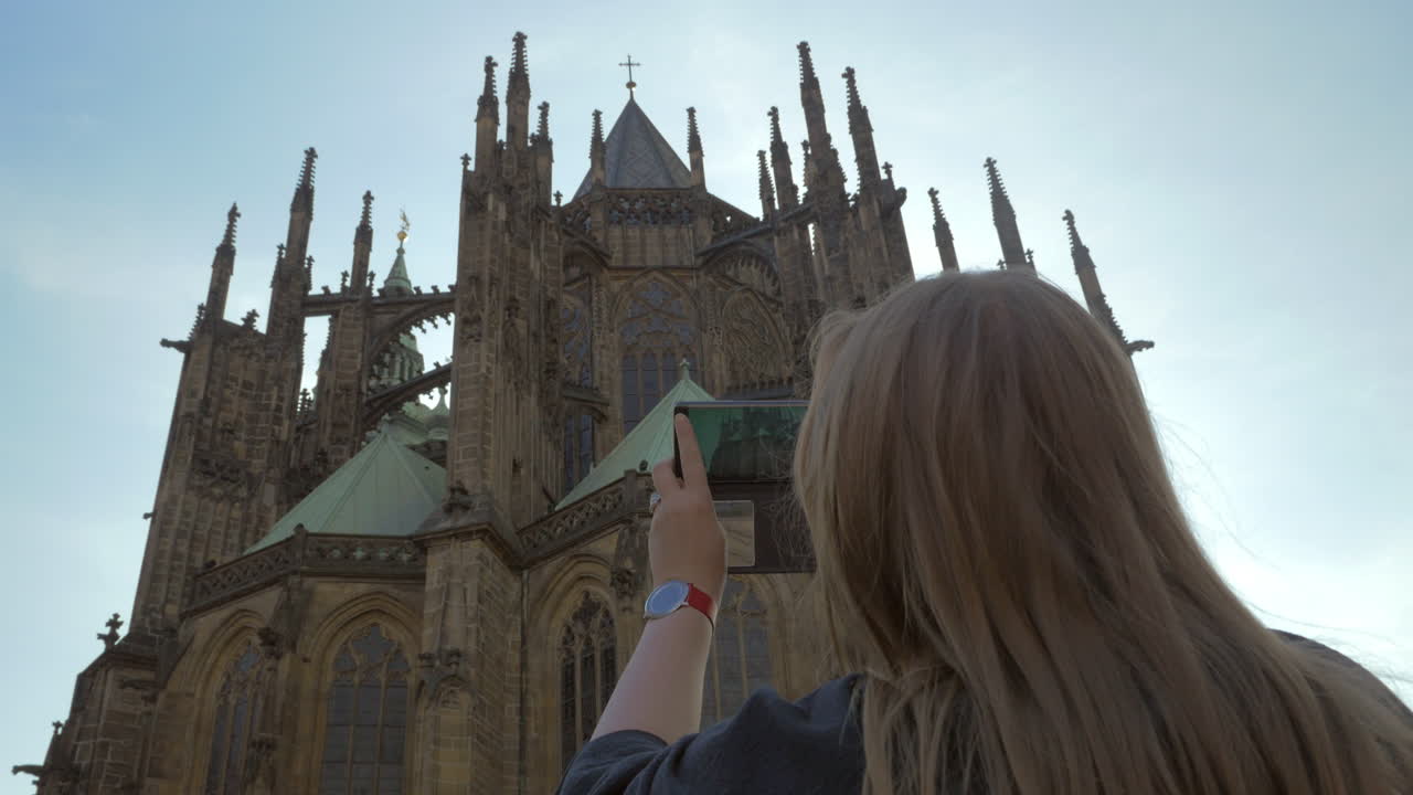 Turista donna che scatta una foto con il cellulare della Cattedrale di San Vito a Praga