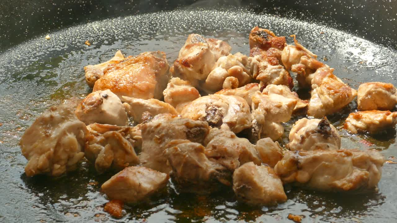 ripresa ravvicinata di pollo fritto per la cottura della paella tradizionale in padella a valencia, in spagna