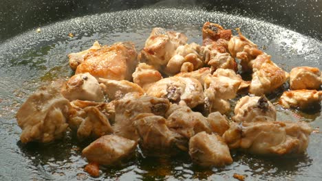 Close-up-shot-of-frying-chicken-for-cooking-traditional-Paella-in-a-pan-in-Valencia,-Spain