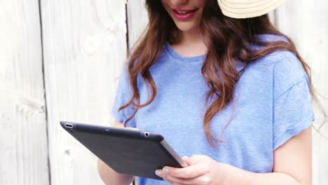 beautiful woman in hat using digital tablet