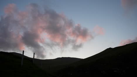 nubes rosadas contrastantes y montañas oscuras al atardecer en eysturoy, islas feroe