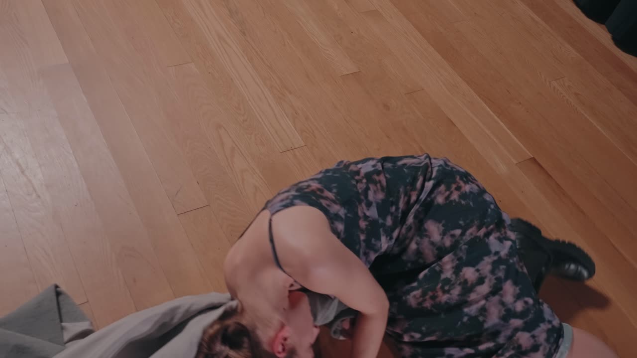 woman expresses inner turmoil through grounded dance on wooden floor