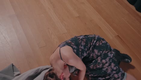 woman expresses inner turmoil through grounded dance on wooden floor