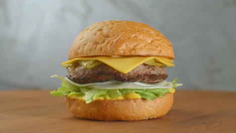 a big tasty burger with meat patty onions vegetables melted cheese lettuce