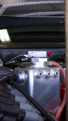 close-up view of a car engine bay with a reservoir and tools