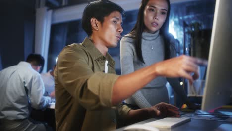 young asian business man and woman work together on desktop computer with team in home office at night. project brainstorm meeting, small business startup, coworker cooperate teamwork concept