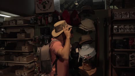 male trying on hats inside a souvenir shop in kruger national park south africa