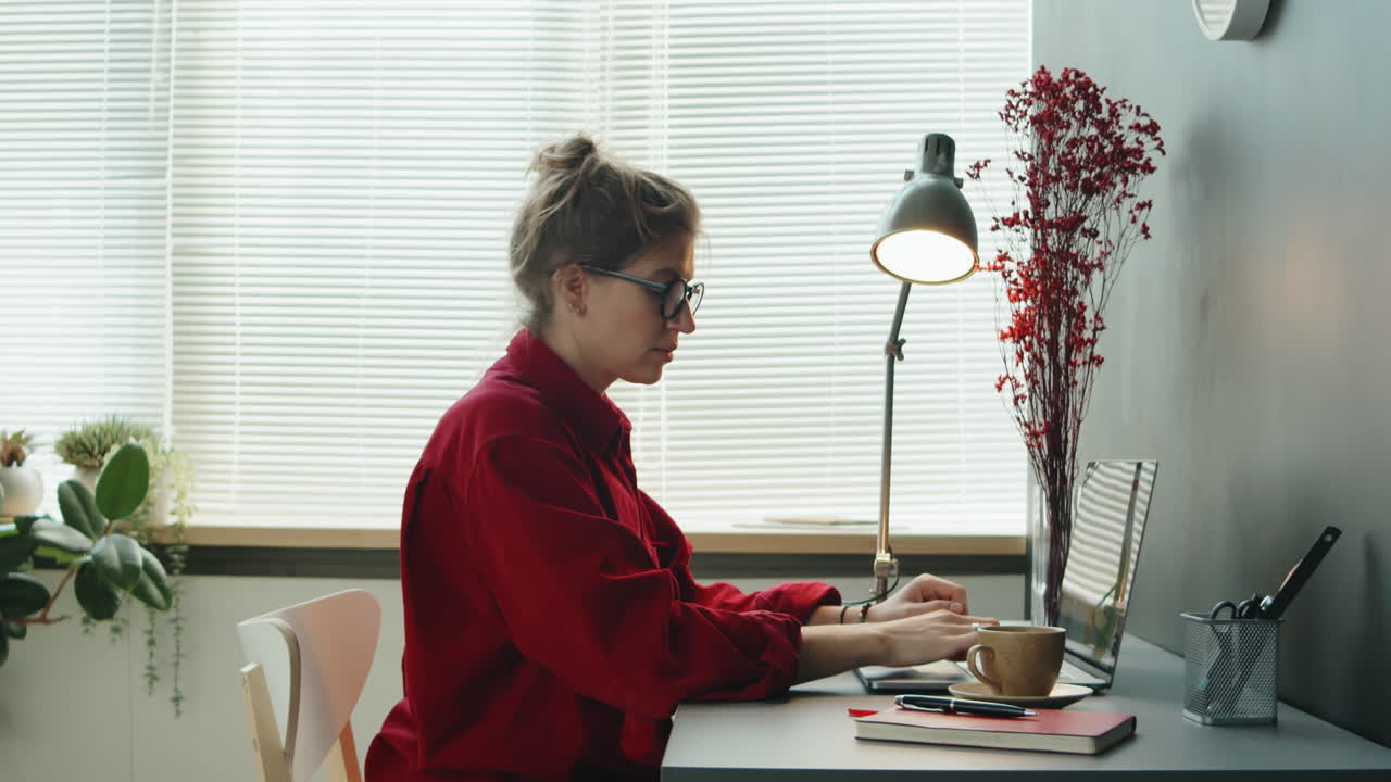 mujer de negocios usando una computadora portátil y bebiendo café en el lugar de trabajo de la oficina