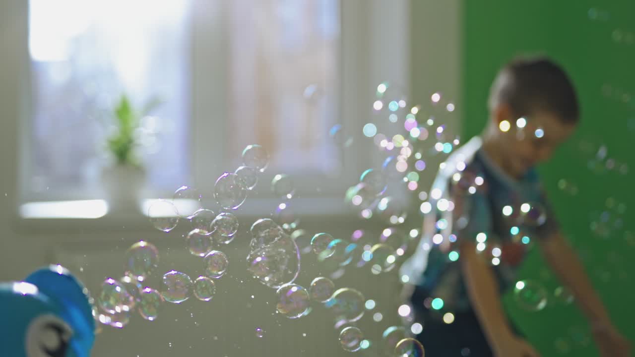Child catching soap bubbles. Boy trying to catching soap bubbles