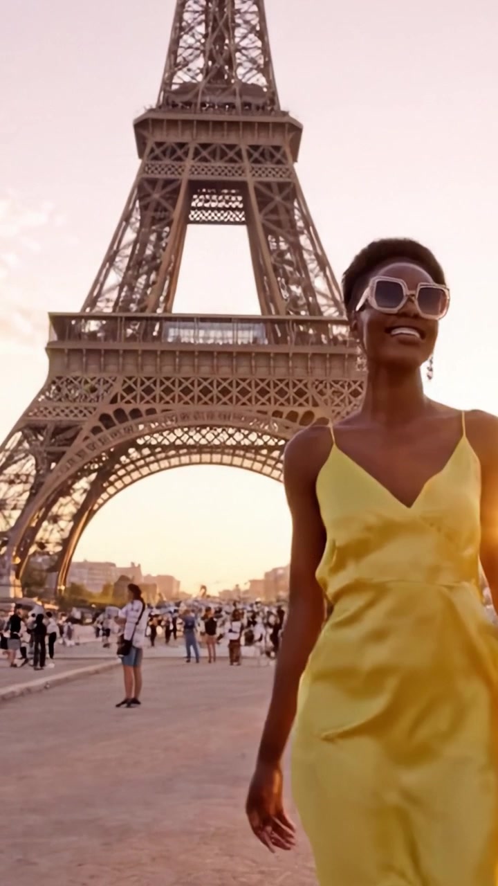 A Fashionable Model Struts Elegantly in a Luminous Yellow Dress Near the Iconic Eiffel Tower, Embracing a Vibrant Sunset in the Heart of Paris.