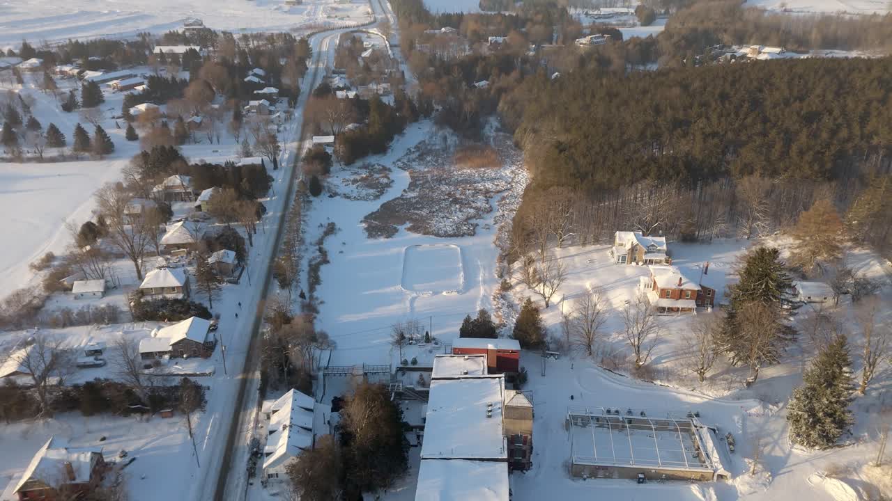 Skating Rink On A Frozen Pond At The Alton Mill In A Rural Town In Caledon, Ontario. Aerial Flyover.